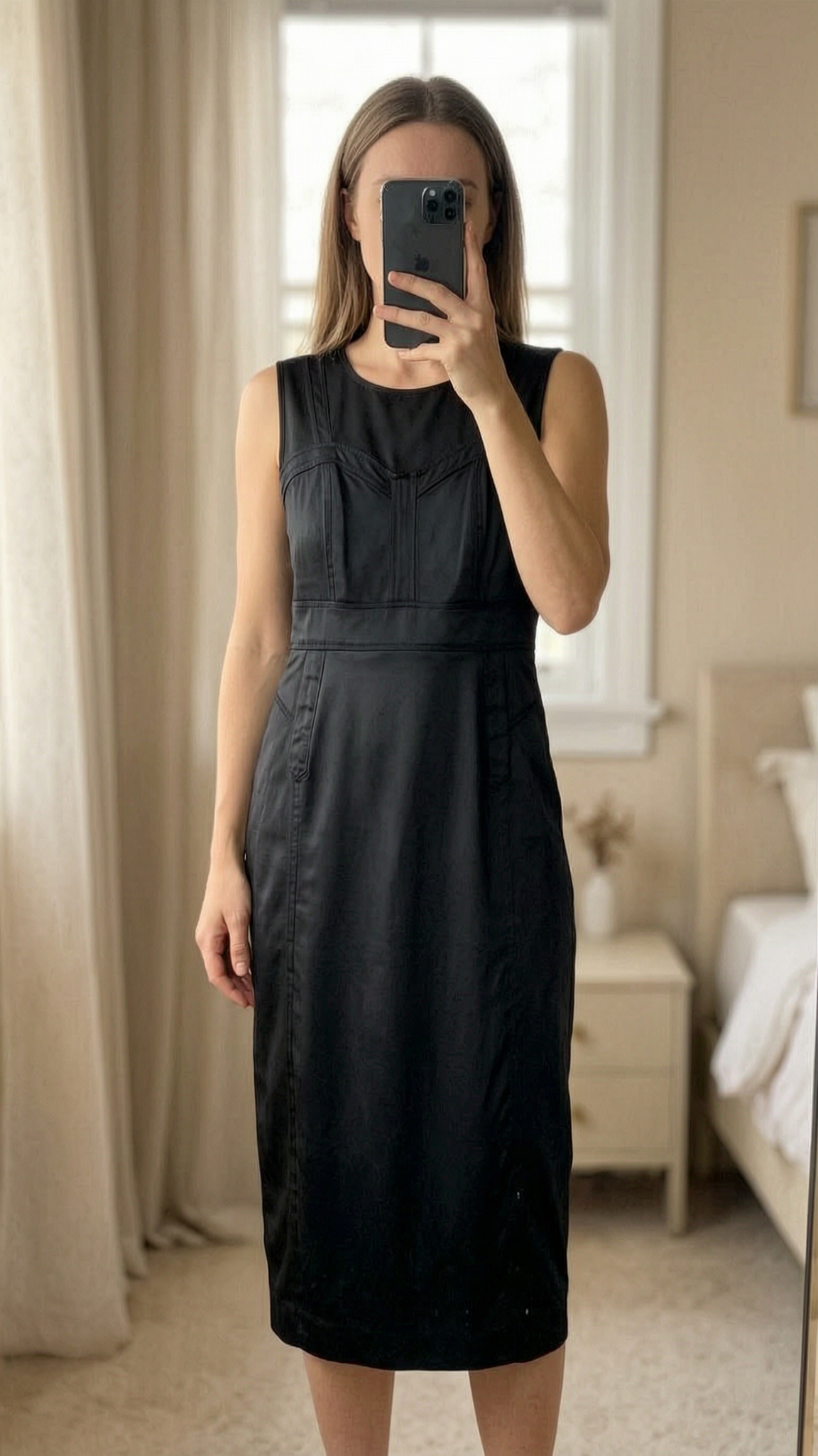 Black Dress Uk10 standing straight facing the camera, in a softly lit bedroom setting, with gentle natural light filtering through a window.