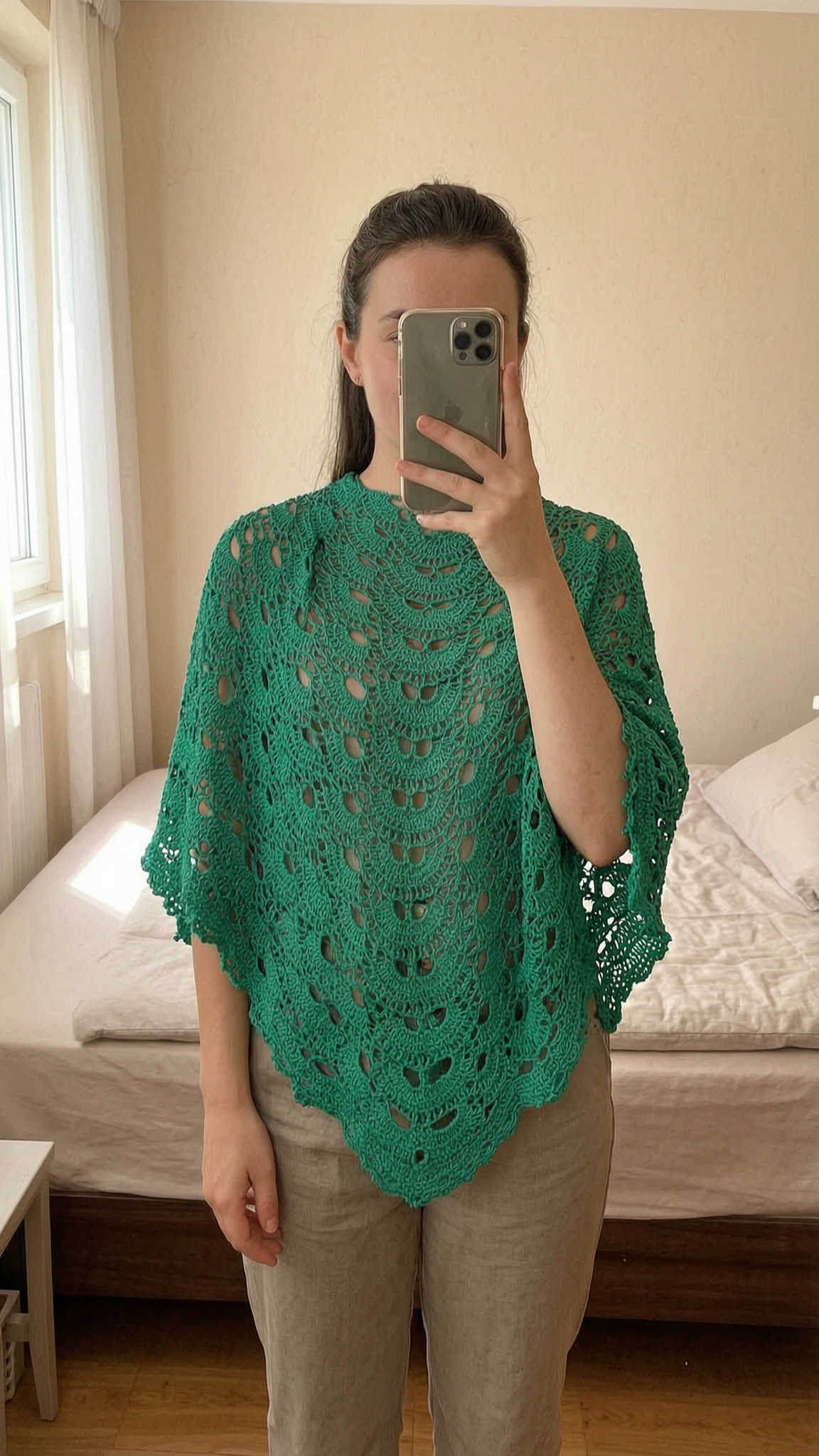 Châle chèche debout, face à la caméra, dans une chambre à la lumière douce, avec une lumière naturelle filtrant par la fenêtre.