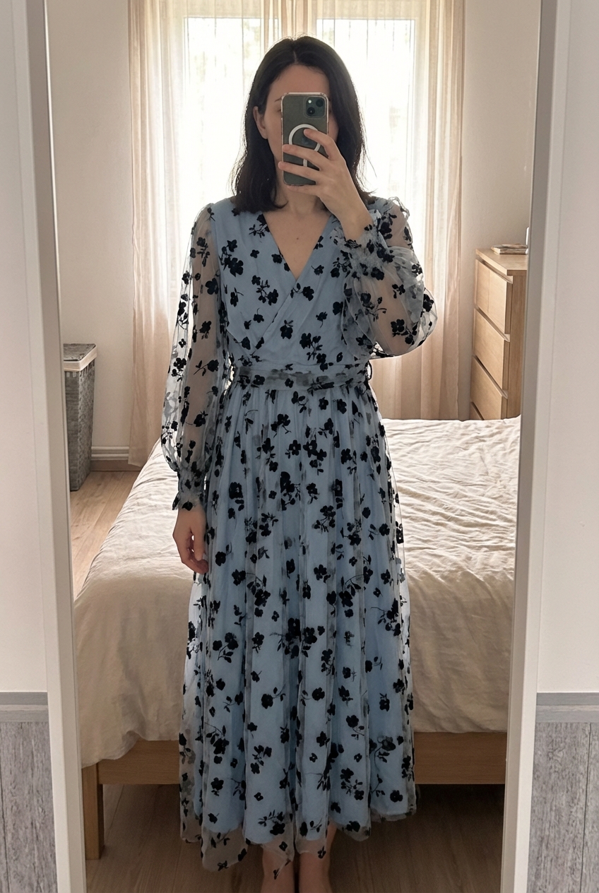 Robe longue fleurie bleu SHEIN taille xl debout, face à la caméra, dans une chambre à la lumière douce, avec une lumière naturelle filtrant par la fenêtre.
