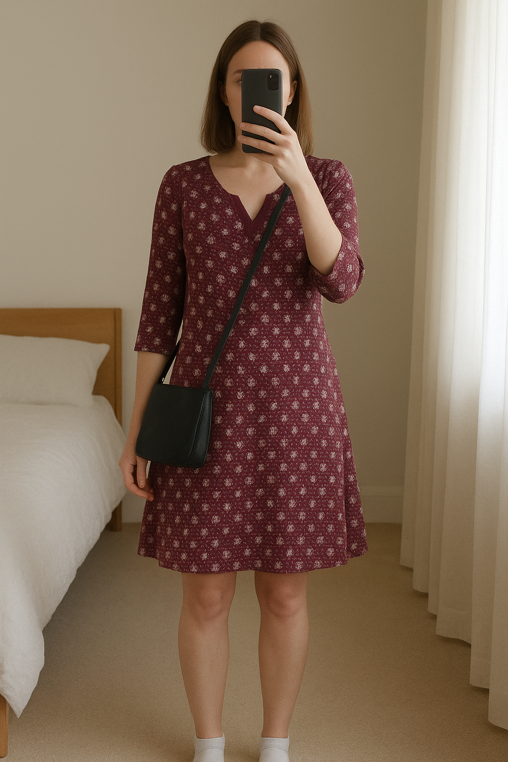 Robe courte Ycoo M debout, face à la caméra, dans une chambre à la lumière douce, avec une lumière naturelle filtrant par la fenêtre.