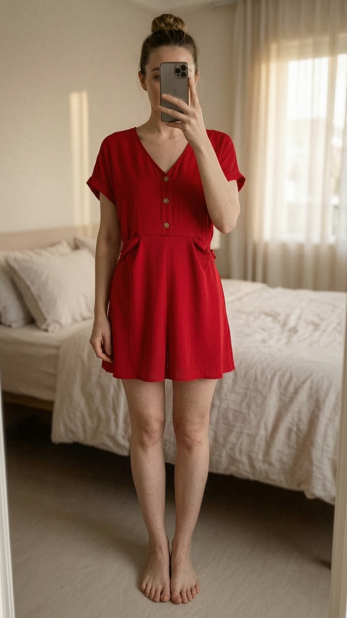 Jolie Combishort été rouge M - tute playsuit estate rosso in piedi, rivolto verso la fotocamera, in una camera da letto con luce soffusa e luce naturale che filtra dalla finestra.
