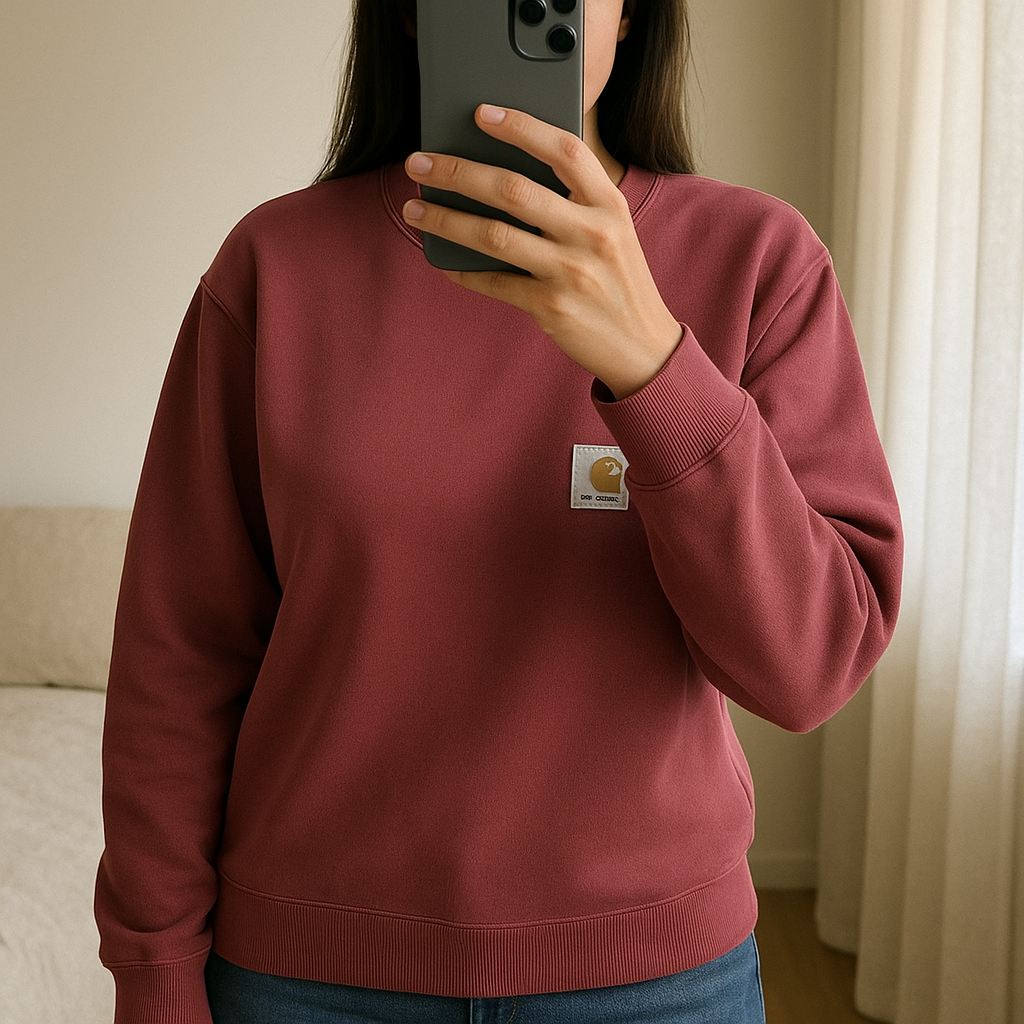 Carhartt WIP Sweatshirt Rouge Red Taille M de pie, mirando a la cámara, en un dormitorio con luz suave y natural filtrándose por la ventana.