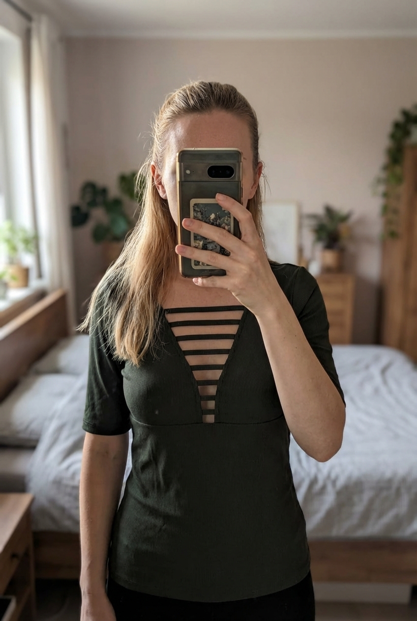 Haut vert foncé H&M col V à lanières – Taille XS debout, face à la caméra, dans une chambre à la lumière douce, avec une lumière naturelle filtrant par la fenêtre.