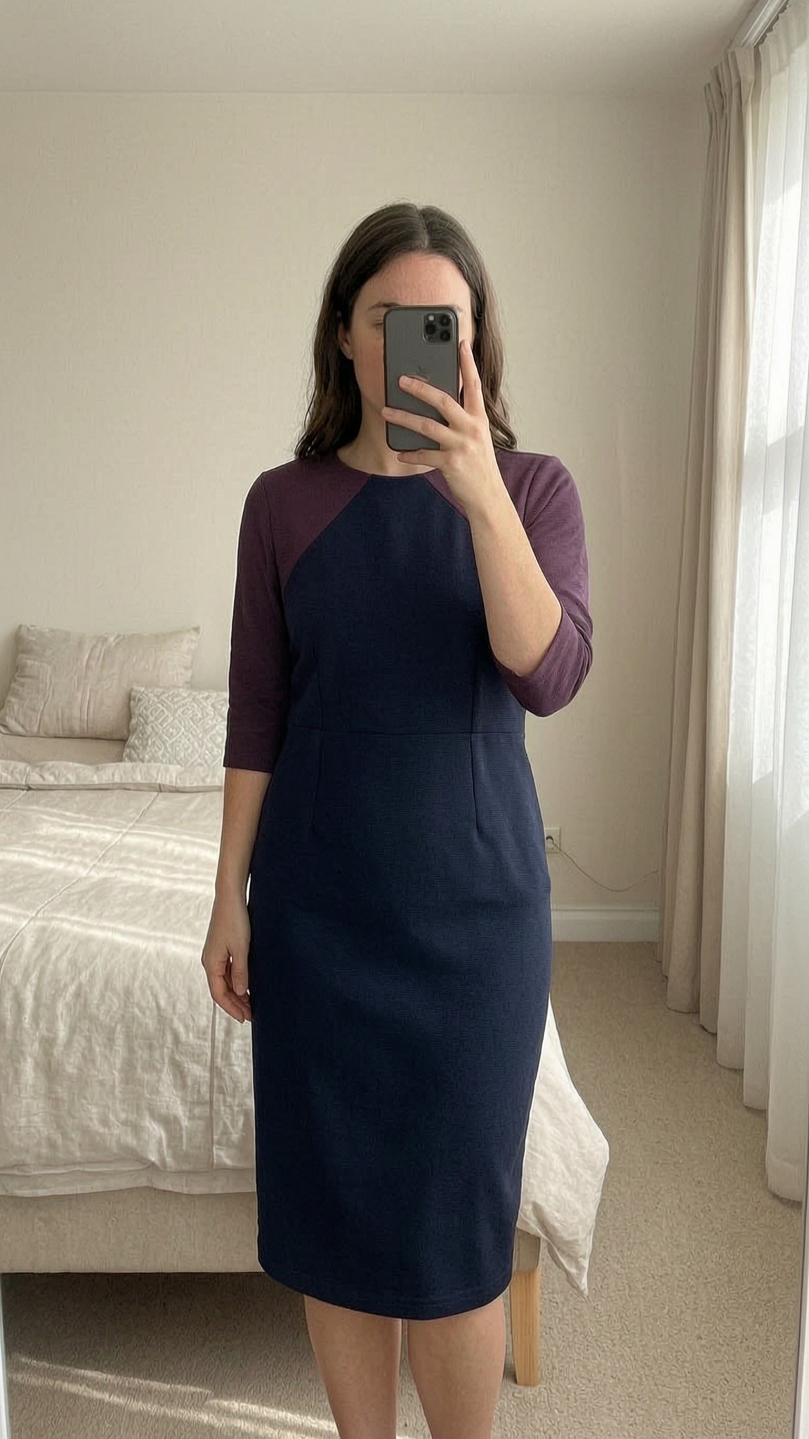 Boden Pencil Dress - Navy Purple - UK 12 standing straight facing the camera, in a softly lit bedroom setting, with gentle natural light filtering through a window.