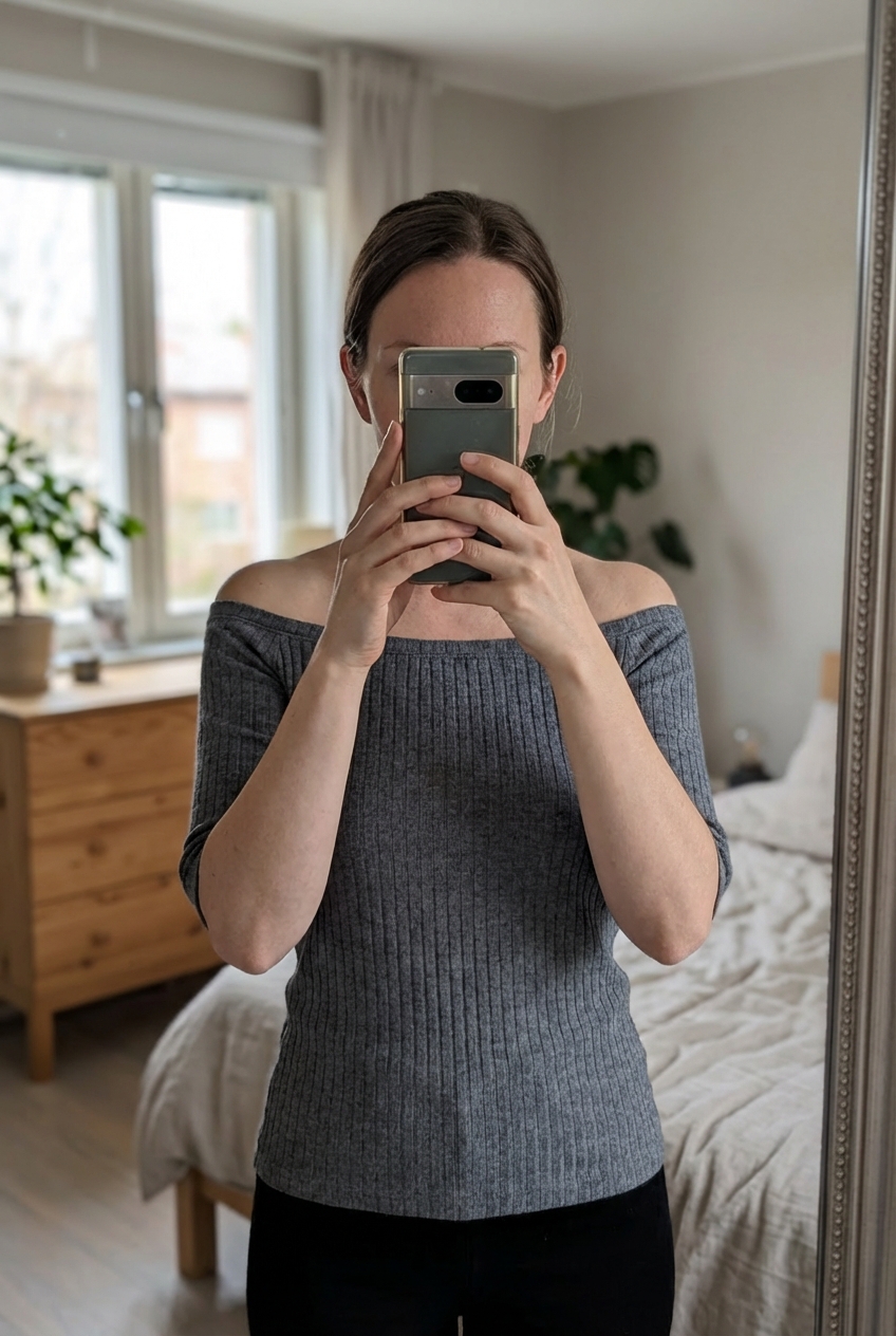 Top gris côtelé à col bateau Pimkie Taille XS debout, face à la caméra, dans une chambre à la lumière douce, avec une lumière naturelle filtrant par la fenêtre.