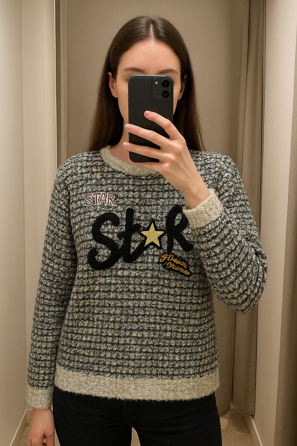 Une personne en Pull star super etat chaud et long taille unique debout, face à la caméra, avec une silhouette fine, dans une cabine d’essayage de style boutique avec un miroir et une décoration neutre.