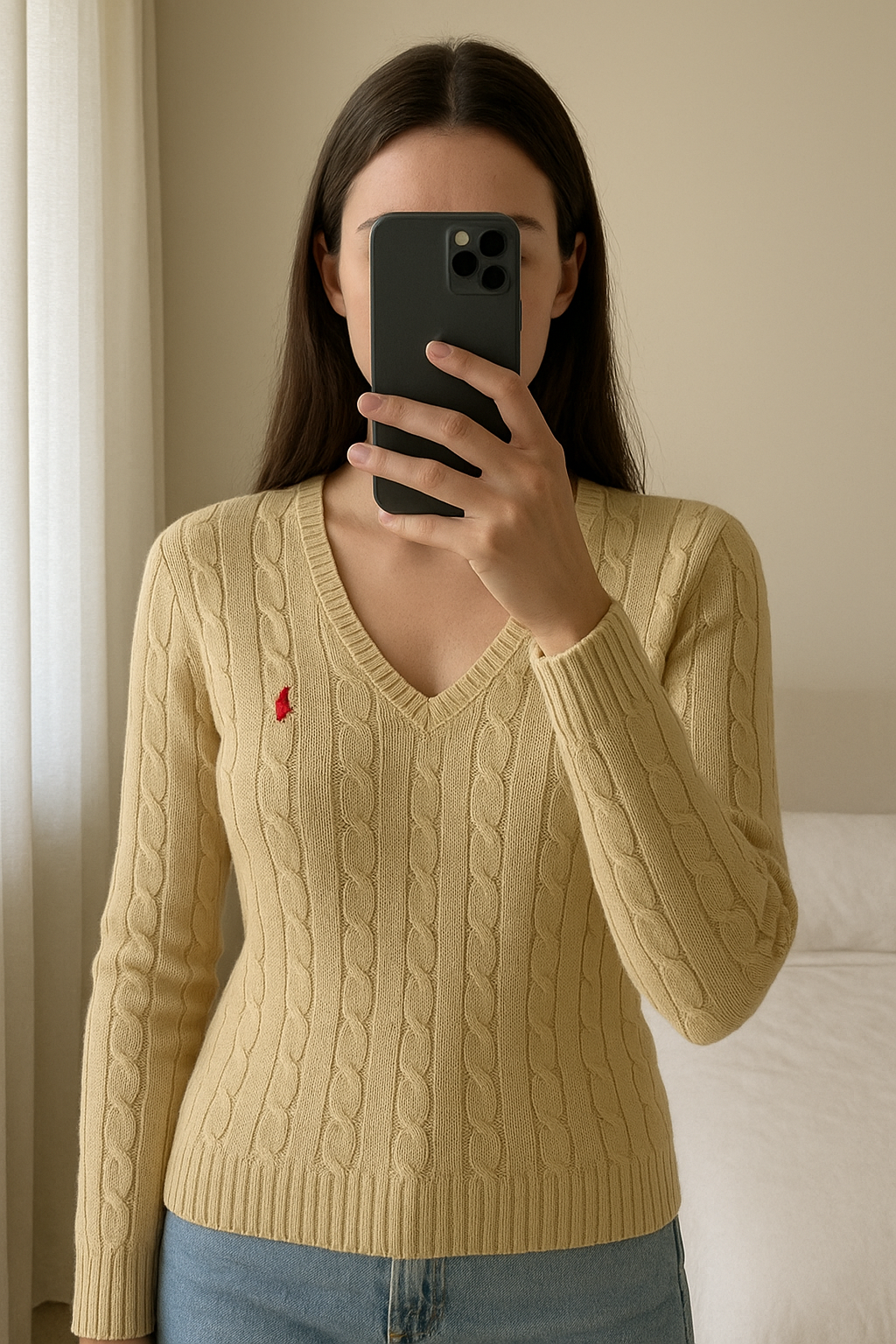 Pull Torsadé Ralph Lauren Femme Beige - Taille S - Old Money - NC12B debout, face à la caméra, dans une chambre à la lumière douce, avec une lumière naturelle filtrant par la fenêtre.