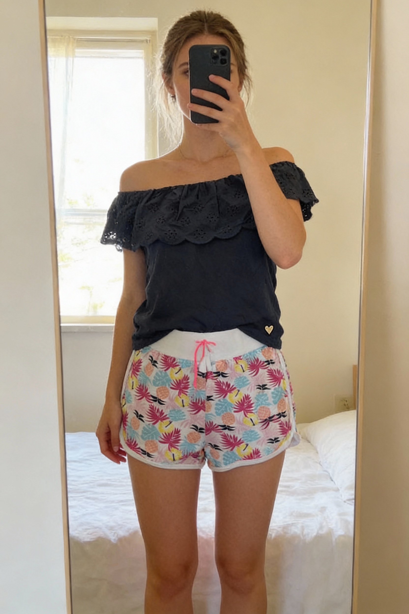 Ensemble fille Lili marelle debout, face à la caméra, dans une chambre à la lumière douce, avec une lumière naturelle filtrant par la fenêtre.